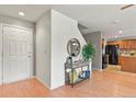 Inviting entryway featuring wood flooring, a console table, a round mirror, and views of the kitchen at 5453 S Quatar Ct, Aurora, CO 80015