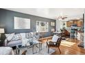 Open-concept living room with hardwood floors and gray painted walls at 1193 S Umatilla St, Denver, CO 80223