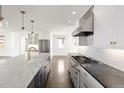 Spacious kitchen with marble island, stainless appliances, and custom white cabinetry at 2025 Ash St, Denver, CO 80207