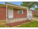 Close-up of front porch showing brickwork, house number, awning, and decorative railing at 11891 Gaylord Way, Northglenn, CO 80233