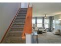 Inviting living room featuring a staircase, comfortable seating, large windows, and stylish decor at 9927 Aftonwood St, Highlands Ranch, CO 80126
