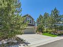 Exterior view of a two-story residence showcasing a three-car garage and professionally landscaped front yard at 1674 Bent Grass Cir, Castle Rock, CO 80109