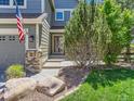 Inviting front entrance features decorative stone accents, a manicured lawn, and elegant landscaping at 1674 Bent Grass Cir, Castle Rock, CO 80109
