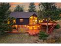 A captivating backyard featuring a spacious deck, mature trees, and exterior home view at 21849 Cabrini Blvd, Golden, CO 80401
