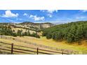 Picturesque landscape view featuring rolling hills, lush trees, and a long fence line at 21849 Cabrini Blvd, Golden, CO 80401