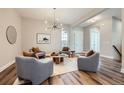Comfortable living room featuring hardwood floors, neutral paint, recessed lighting, and a modern light fixture at 574 Agoseris Way, Castle Rock, CO 80104