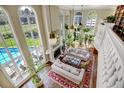High-ceilinged living area with hardwood floors and pool view at 900 E Kenyon Ave, Cherry Hills Village, CO 80113