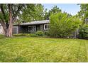 A cozy home featuring a lush green lawn and mature trees at 5436 E Atlantic Pl, Denver, CO 80222