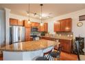 Kitchen features stainless steel appliances, breakfast bar, cherry cabinets, and hardwood floors at 13456 Via Varra # 225, Broomfield, CO 80020