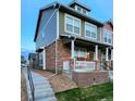 Side view of a charming two-story home with a stone facade and covered front porch at 13640 Garfield St # A, Thornton, CO 80602
