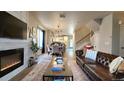 Open-concept living room with a fireplace, hardwood floors, and abundant natural light at 13640 Garfield St # A, Thornton, CO 80602