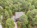 Aerial view of a gray home nestled amongst a dense forest of green trees at 510 Silhouette Way, Monument, CO 80132