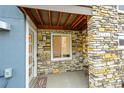 Cozy entryway featuring stone accents, a welcome mat and a covered porch at 6745 S Tempe Ct, Aurora, CO 80016