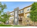 Stylish multi-level condo featuring stone accents, modern gray accents, and a charming balcony at 6745 S Tempe Ct, Aurora, CO 80016
