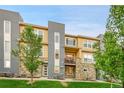 Stylish multi-level condo featuring stone accents, modern gray accents, and a charming balcony at 6745 S Tempe Ct, Aurora, CO 80016