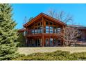 Charming two-story home featuring a balcony with a beautiful wood finish and lush landscaping at 40 Charlou Cir, Cherry Hills Village, CO 80111