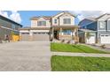 Inviting two-story home with a three car garage, covered porch, and manicured lawn at 13486 Valentia St, Thornton, CO 80602