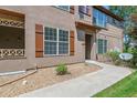 Close-up of townhome exterior featuring a gravel garden, charming shutters, and a covered entrance at 11972 W Long Cir # 104, Littleton, CO 80127