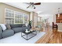 Bright living room features a ceiling fan, hardwood floors, and large window with natural light at 11972 W Long Cir # 104, Littleton, CO 80127