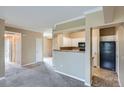 Open-concept living room featuring a kitchen with white cabinets and neutral paint at 7493 S Quail Cir # 928, Littleton, CO 80127