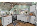Modern kitchen showcasing stainless steel appliances, a farmhouse sink, and a window overlooking the backyard at 3270 Depew St, Wheat Ridge, CO 80212