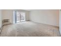 Spacious living room with neutral carpet and access to a private balcony at 655 S Alton Way # 6C, Denver, CO 80247