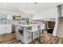 Bright kitchen featuring an island with bar seating, stainless steel appliances, and wood-look floors at 7649 E Amherst Ave, Denver, CO 80231