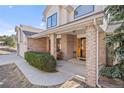 Inviting front porch with brick columns, mature shrubbery, and a quaint seating area at 426 Buena Vista Rd, Golden, CO 80401
