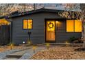 Close-up of a cozy home's entrance, showcasing a warm wooden door, stylish lighting, and well-maintained landscaping at 8120 W 54Th Pl, Arvada, CO 80002