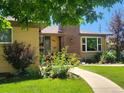 Charming brick home with landscaped front yard, walkway, and inviting curb appeal at 1594 S Locust St, Denver, CO 80224