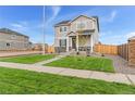 Two-story house with gray siding, stone accents, and a landscaped lawn at 22293 E 6Th Pl, Aurora, CO 80018