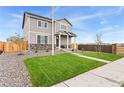 Two-story house with gray siding, stone accents, and a landscaped lawn at 22293 E 6Th Pl, Aurora, CO 80018