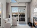 Cozy sitting area with stylish chairs, a small table, and a view of the outdoors near a modern fireplace at 345 Fillmore St # 407, Denver, CO 80206