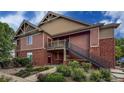 Close-up of a tan and brick condo complex with a second story landing and staircase at 804 Summer Hawk Dr # 5105, Longmont, CO 80504