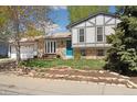 Charming two-story home with a manicured lawn, rock garden, blue front door, and a spacious two-car garage at 1309 Alexandria St, Lafayette, CO 80026