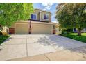 Charming two-story home with a three-car garage, well-maintained lawn, and beautiful landscaping at 16084 Stonebriar Dr, Parker, CO 80134