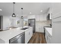 Bright kitchen featuring white cabinets, stainless steel appliances, quartz countertops, and modern pendant lighting at 5292 Columbine Ln, Denver, CO 80221