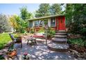 Inviting front yard with a swing, patio, and well-manicured landscaping and a red door at 6360 S Kendall St, Littleton, CO 80123