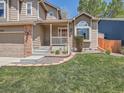 Charming home exterior featuring a well-manicured lawn, front porch and a red front door at 13358 Briarwood Dr, Broomfield, CO 80020