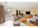 Cozy living room with neutral tones, comfortable seating, and a sliding door leading to the backyard at 2888 S Fundy St, Aurora, CO 80013