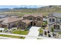 Aerial view of a two-story stucco home with tile roof, attached garage and long driveway at 2125 S Orion St, Lakewood, CO 80228