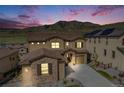 A warm sunset view of a stone-accented home, highlighting its architectural details and landscaping at 2125 S Orion St, Lakewood, CO 80228