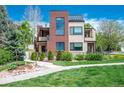 Beautiful modern home featuring a manicured lawn, brick accents, and lush landscaping at 402 Garfield St, Denver, CO 80206