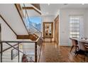 Spacious hallway with a staircase, hardwood floors, a large decorative mirror, and ample natural light at 402 Garfield St, Denver, CO 80206