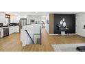 Bright hallway featuring modern decor with a decorative black wall, light floors, and a white kitchen at 6894 Nelson St, Arvada, CO 80004