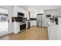 Stylish kitchen with white cabinets, stainless steel appliances, and modern black backsplash at 6894 Nelson St, Arvada, CO 80004