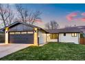 A charming single-story home with a well-manicured lawn and an attached garage at 6142 Dudley Ct, Arvada, CO 80004