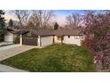 Single-story home with a well-manicured lawn and an attached two-car garage at 6142 Dudley Ct, Arvada, CO 80004