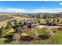 Expansive aerial view of home, well manicured lawn and landscaping, large trees, and beautiful mountain views at 3891 Windchant Cir, Castle Rock, CO 80104