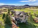Aerial view of a large home with a deck and sprawling views of rolling hills and other homes at 3891 Windchant Cir, Castle Rock, CO 80104